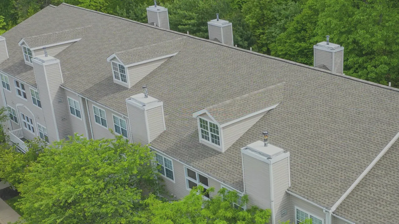 Aerial view of a completed shingle roof on a multi-unit residential building